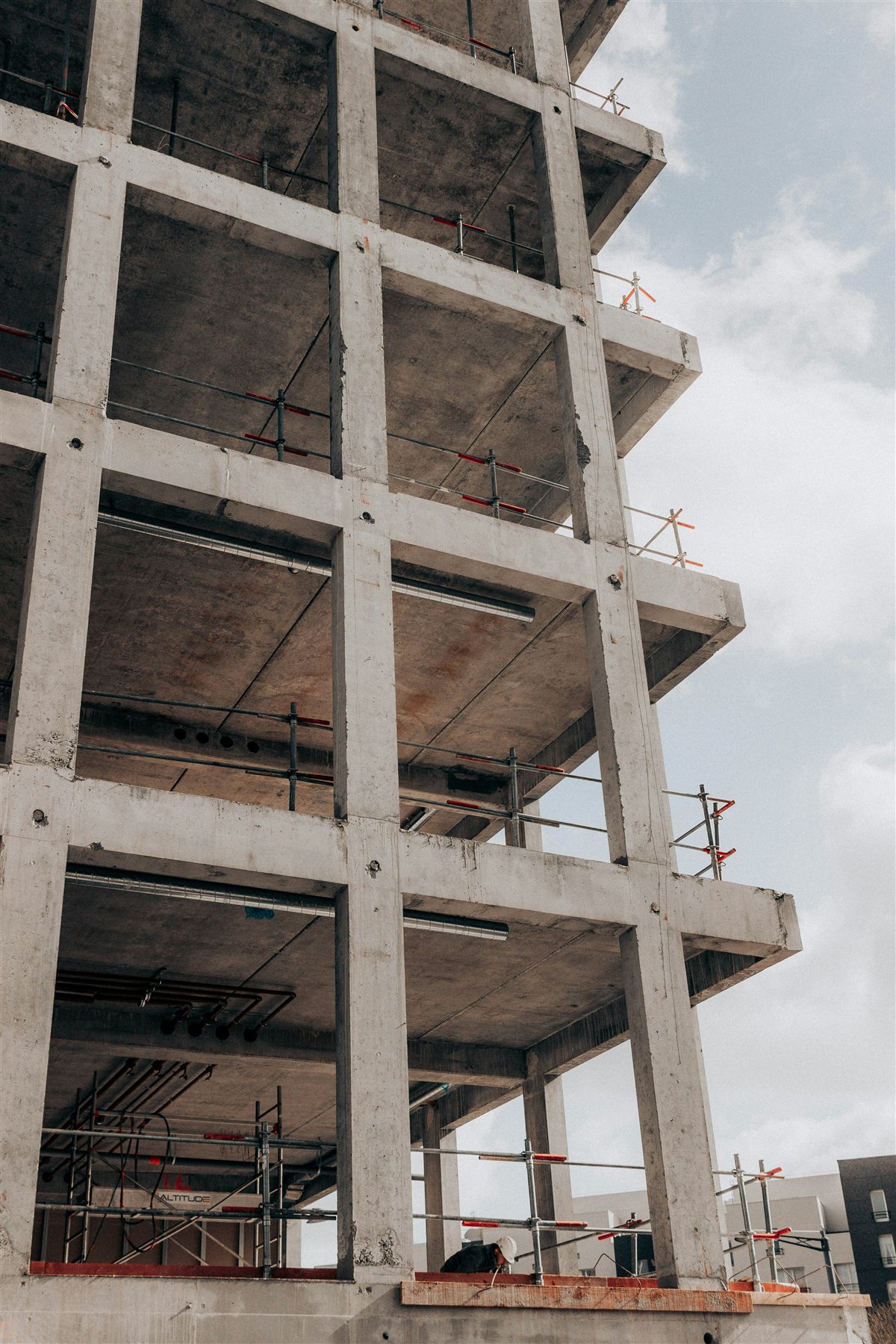 Bâtiment en béton armé en cours de construction, ossature de poteaux et planchers reprenant les charges vers les fondations