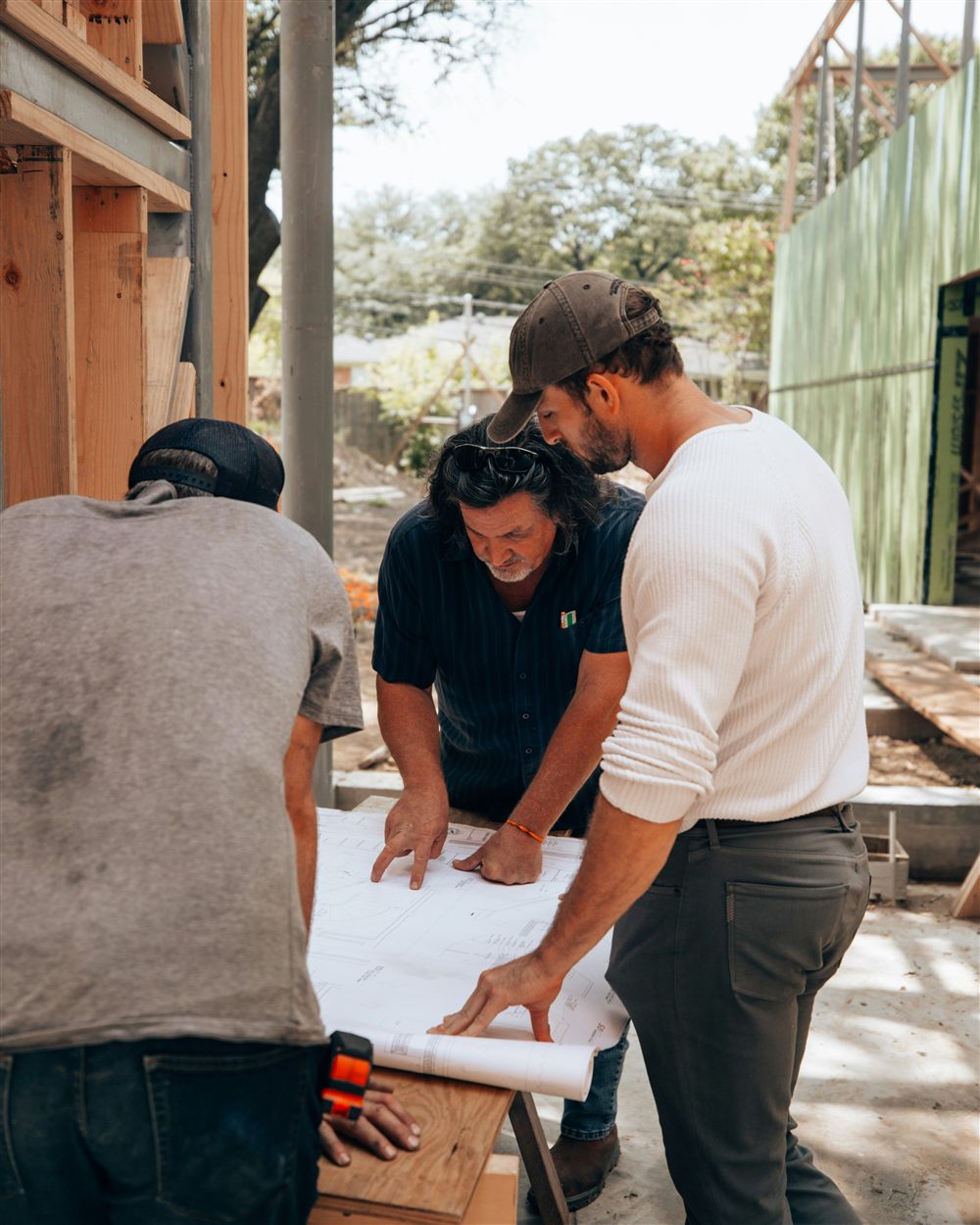 Professionnels du bâtiment étudiant des plans de structure sur un chantier avant le dimensionnement des éléments