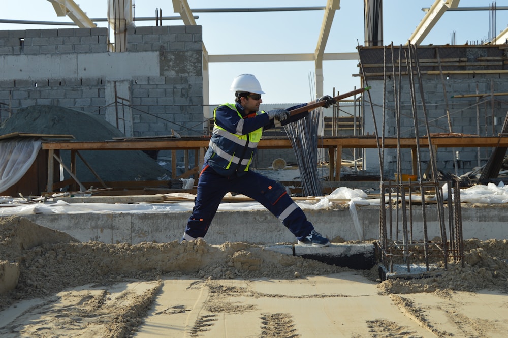 Ouvrier positionné près d'armatures acier sur chantier — vérification de la mise en œuvre des renforts structurels