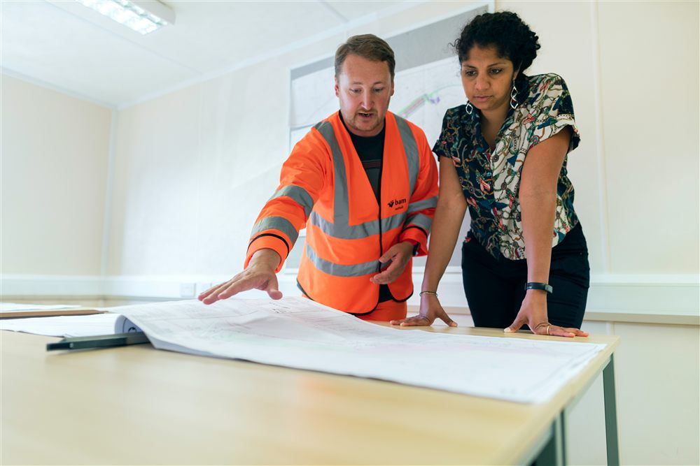 Deux ingénieurs examinant un ouvrage sur un chantier, illustrant un diagnostic structurel sur site