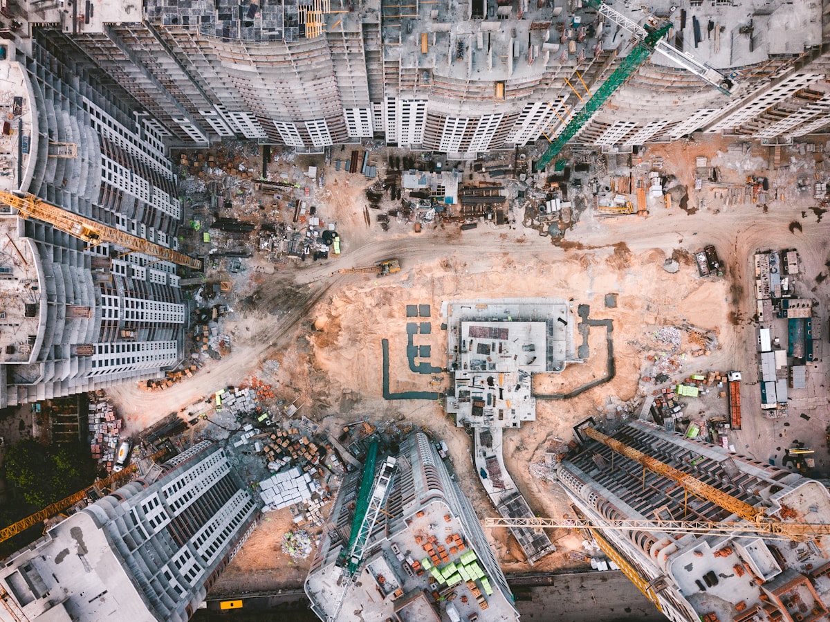 Vue aérienne d'un immeuble en béton armé de grande hauteur — structure parasismique avec contreventements et joints de dilatation visibles