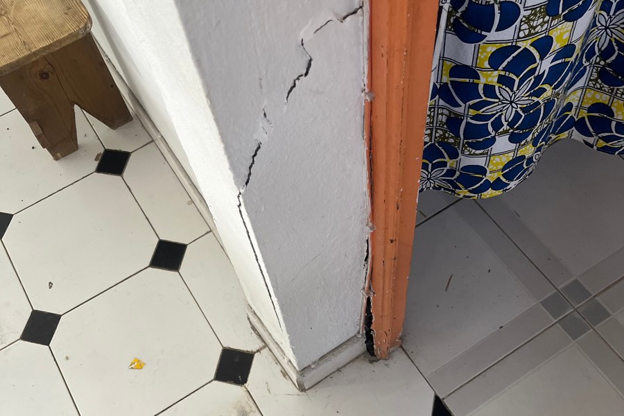 Fissure oblique à la base d'un mur intérieur près d'un encadrement de porte
