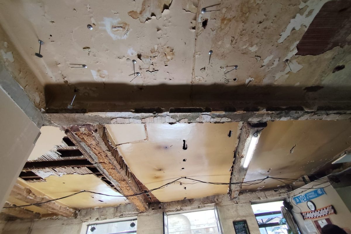 Plafond d'un bar ancien à Montpellier : poutre bois apparente et solives dégagées après dépose des plâtres