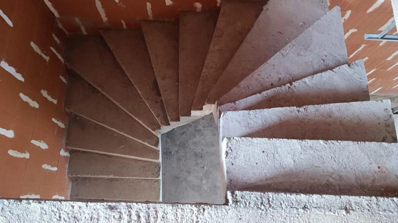 Vue de dessus de l'escalier : deux volées à marches balancées, paillasse en béton brut de décoffrage