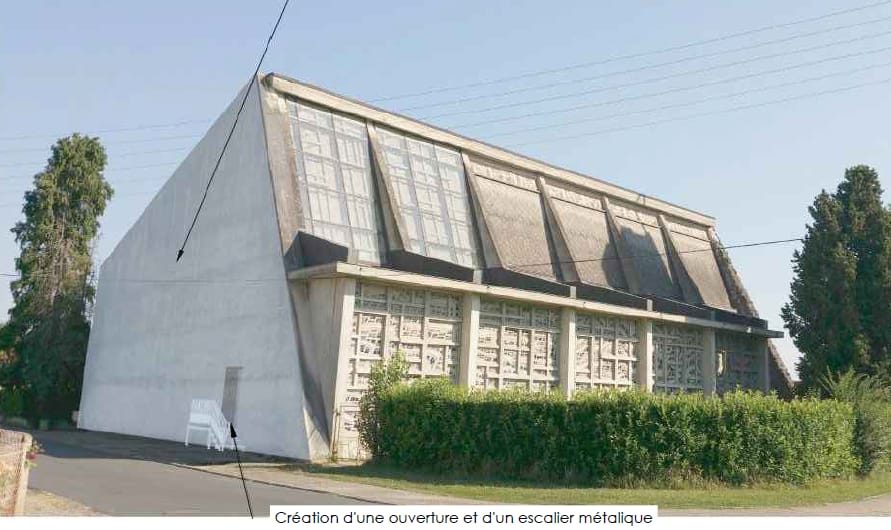 Façade de l'église : grand pignon vitré et voiles en béton brut, emplacement prévu de l'ouverture et de l'escalier