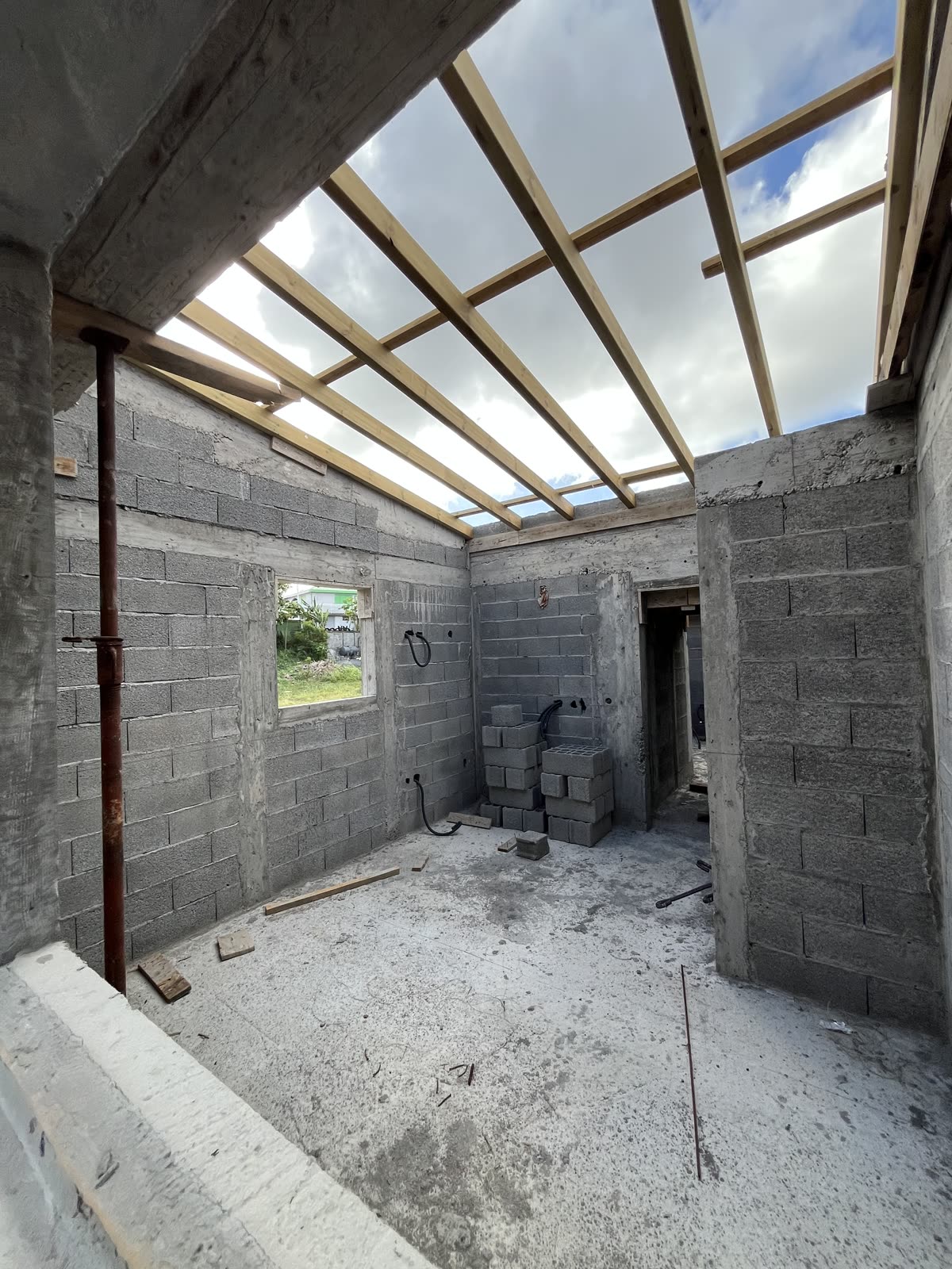Vue intérieure avec charpente bois apparente et murs bloc béton
