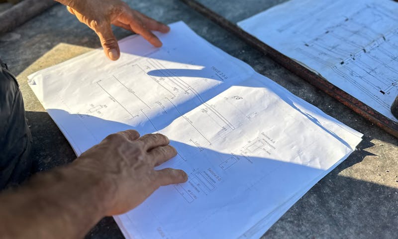 Mains d'ingénieur consultant des plans structurels sur chantier